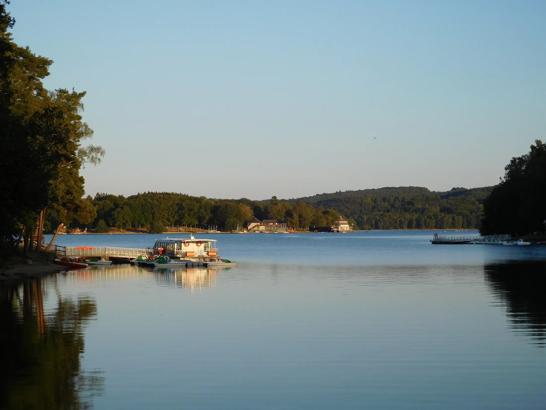 Lac des Settons avec un bateau et des rives boisées