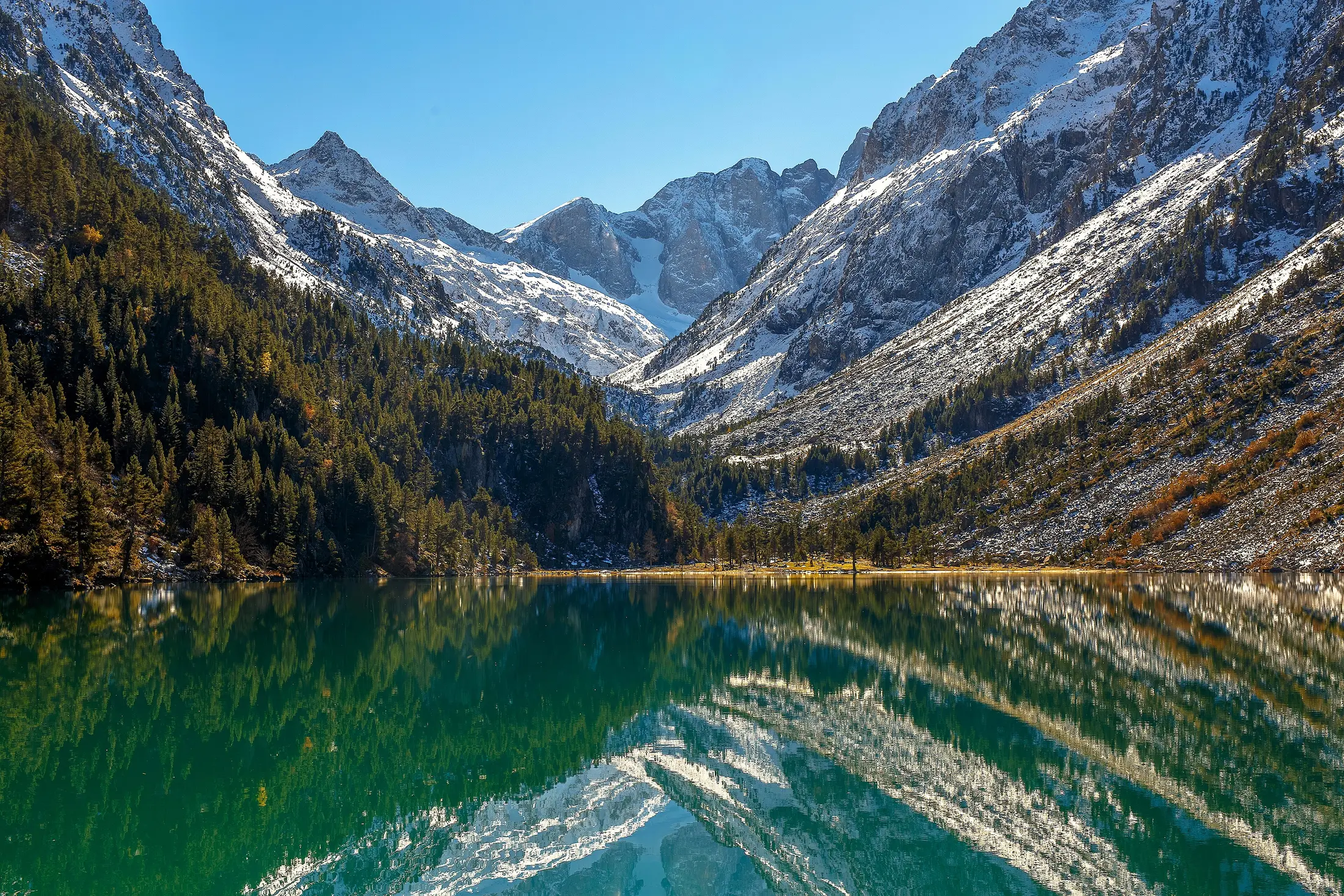 Lac de Gaube reflétant les montagnes et les couleurs dorées de l’automne